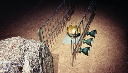 Detail of Le poisson rêveur installation with ceramics, stone, sand and metal fencing