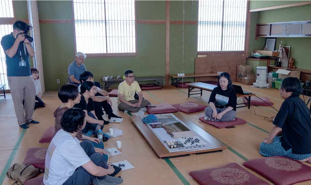 Participants gathered around the Shell/Habitat installation in a tatami room